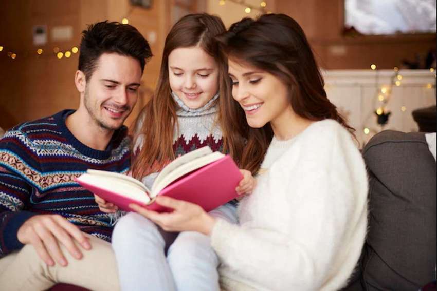 Padres leyendo cuento con su hija